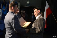 Komendant Piotr Kucia gratulujący jubileuszu kapelanowi policji księdzu Mariuszowi Olejnikowi.