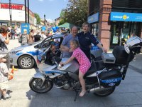 Policjantka z tatą małej dziewczynki siedzącej na motocyklu
