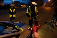 Policjanci wręczający odblaski dzieciom