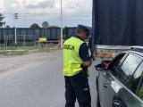 policjant wrącza kierowcy ulotkę dot. bezpiecznego przejazdu kolejowego