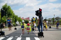 na zdjęciu dwójka dzieci trzymających się za ręce w miasteczku ruchu drogowego