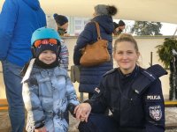 policjantka z dzieckiem na tle lodowiska