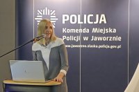 kobieta  przemawia w tle baner policyjny