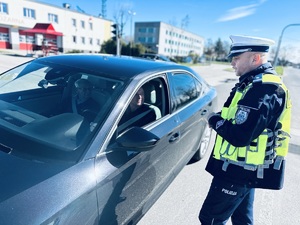 na zdjęciu umundurowany policjant ruchu drogowego rozmawia z kierowcom