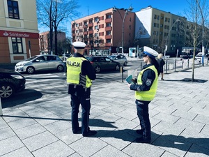na zdjęciu dwóch umundurowanych policjantów obserwuje przejście dla pieszych